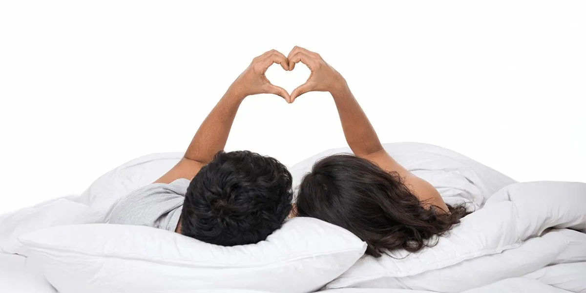 A couple making a heart shape with their hands